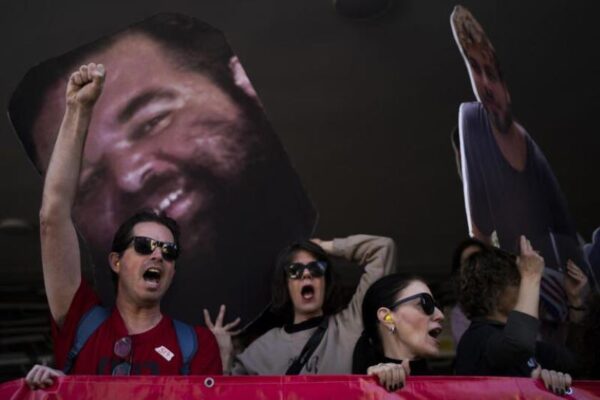 Demonstrators hold photos depicting the faces.