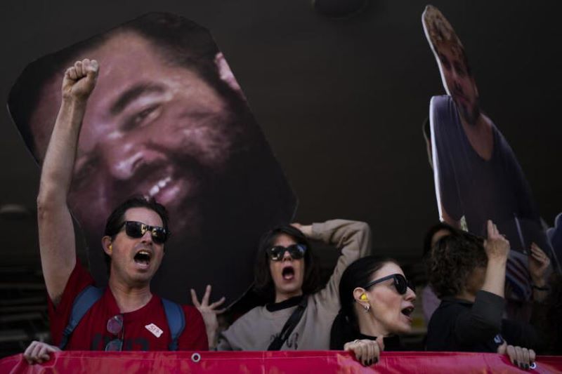 Demonstrators hold photos depicting the faces.