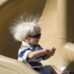 This boy has been sliding down a plastic slide