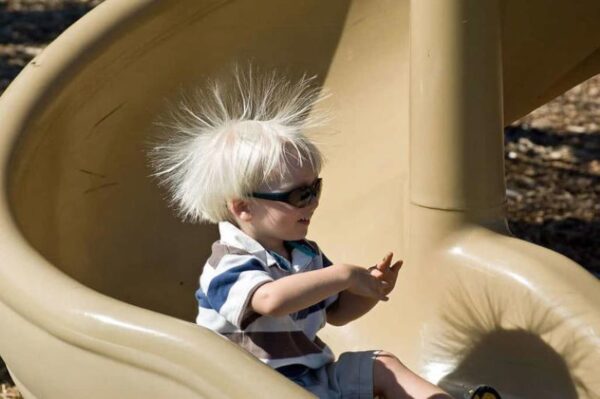 This boy has been sliding down a plastic slide