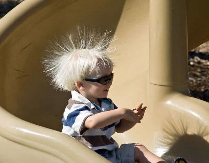 This boy has been sliding down a plastic slide