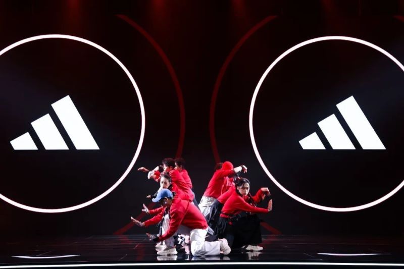 Dancers performing on stage with adidas logos