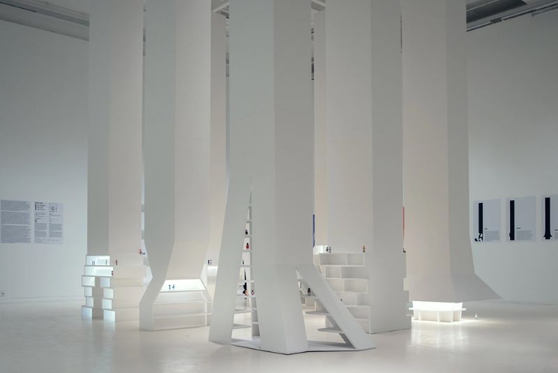 White architectural installation with mini figures in gallery space